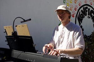 Mathias Werner am Keyboard, schaut in die Kamera, Hände auf den Tasten