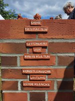 Schrift auf Ziegelchen auf einer Ziegelmauer