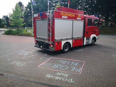 Feuerwehrauto auf dem Feuerwehrvorplatz, Zeichnungen auf dem Boden