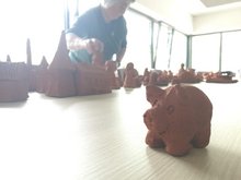 Tonschwein vorn mit Tonfiguren im Hintergrund
