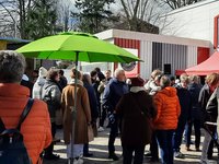 Viele Menschen versammeln sich vor einer Bühne mit Musikern 