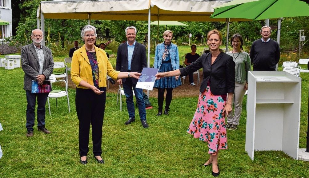 Übergabe des Förderbescheids für Kreiskultur Die Ministerin und die Kreispräsidentin halten gemeinsam den Förderbescheid in die Luft. Dahin stehen die Leitungspersonen der Kultureinrichtungen.