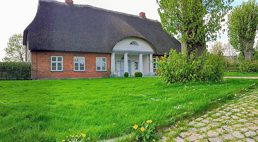 Dorfmuseum Sehestedt Backsteinhaus mit Reeddach und Säuleneingang auf Wiese